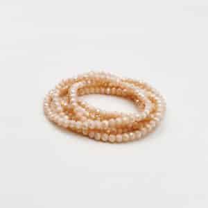 Bracelet perles verre Rose  Joli bracelet monté sur élastique vous permettant de faire plusieurs fois le tour de votre poignet Ce bijou est composé d'une multitude de petites perles en cristal, verre de couleur rose pâle