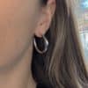 Boucles d’oreilles en acier inoxydable de couleur argentée, composées de deux créoles travaillées