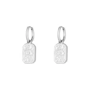 Boucles d’oreilles en acier inoxydable de couleur argent, composées de deux créoles lisses avec pendentif de forme rectangulaire gravé d’un oeil de protection avec strass en son centre