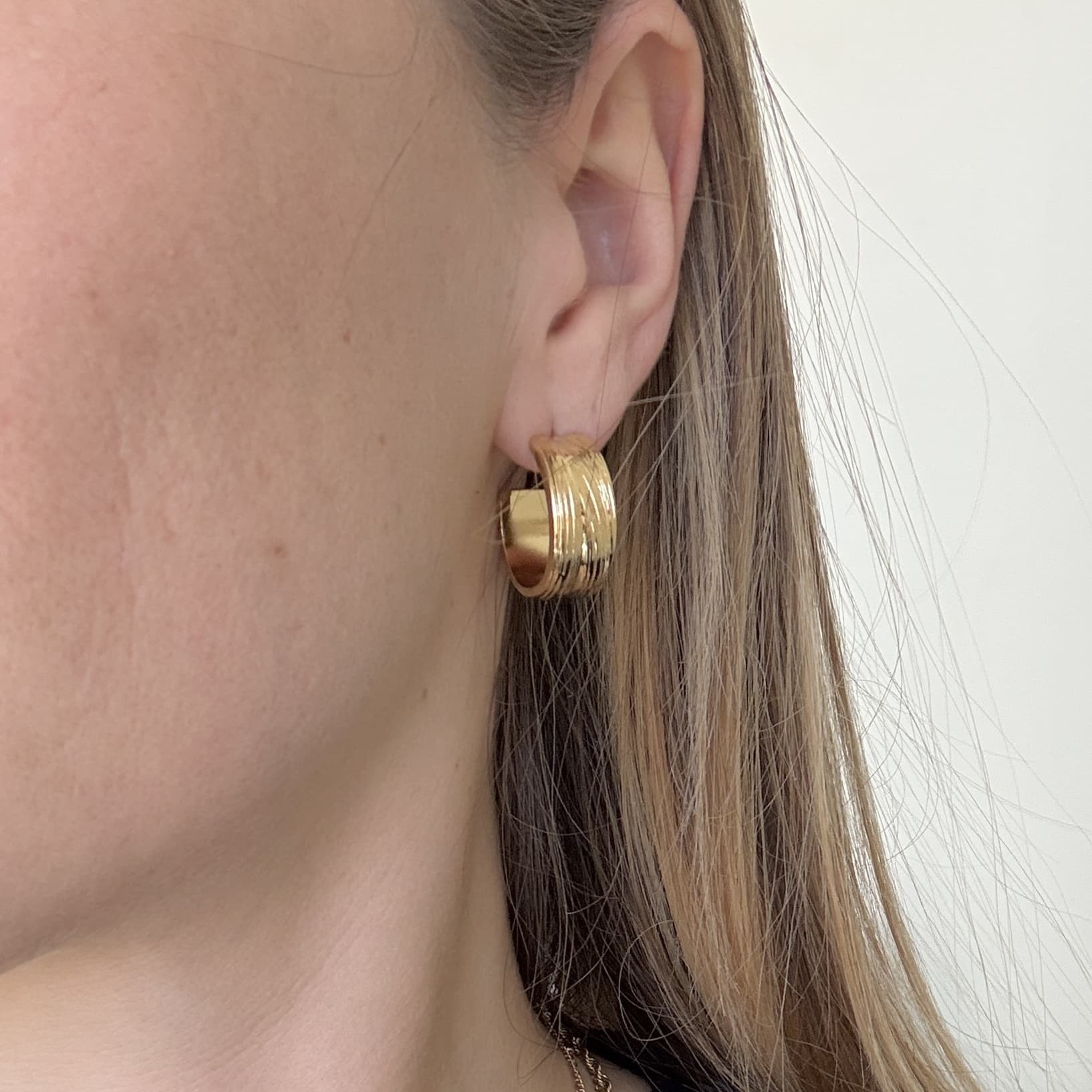 Boucles d’oreilles en acier inoxydable de couleur or, composées de deux créoles rondes très joliment martelées , à la fois chic et vintage