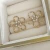 Boucles d’oreilles en acier inoxydable de couleur or, composées de deux puces d’oreilles travaillées, à la fois chic et vintage, en forme de fleurs et dotées de petites perles d'eau douce en leur centre
