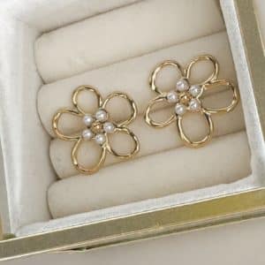 Boucles d’oreilles en acier inoxydable de couleur or, composées de deux puces d’oreilles travaillées, à la fois chic et vintage, en forme de fleurs et dotées de petites perles d'eau douce en leur centre