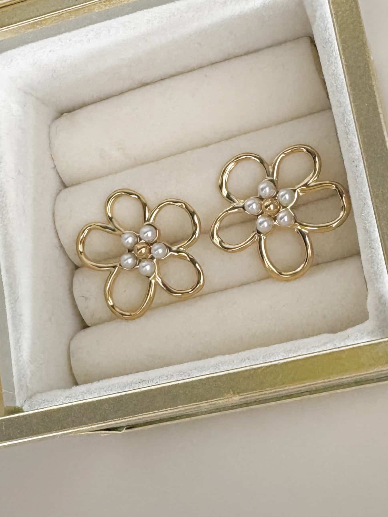 Boucles d’oreilles en acier inoxydable de couleur or, composées de deux puces d’oreilles travaillées, à la fois chic et vintage, en forme de fleurs et dotées de petites perles d'eau douce en leur centre