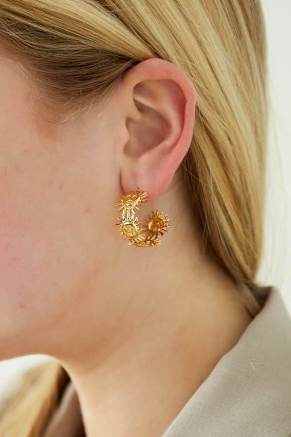 Boucles d’oreilles en acier inoxydable de couleur or, composées de deux créoles larges avec soleils souriants en ribambelle