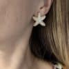 Boucles d’oreilles en acier inoxydable de couleur or, composées de deux puces d’oreilles travaillées, à la fois chic et vintage, en forme d’étoiles de mer serties de perles d'eau douce