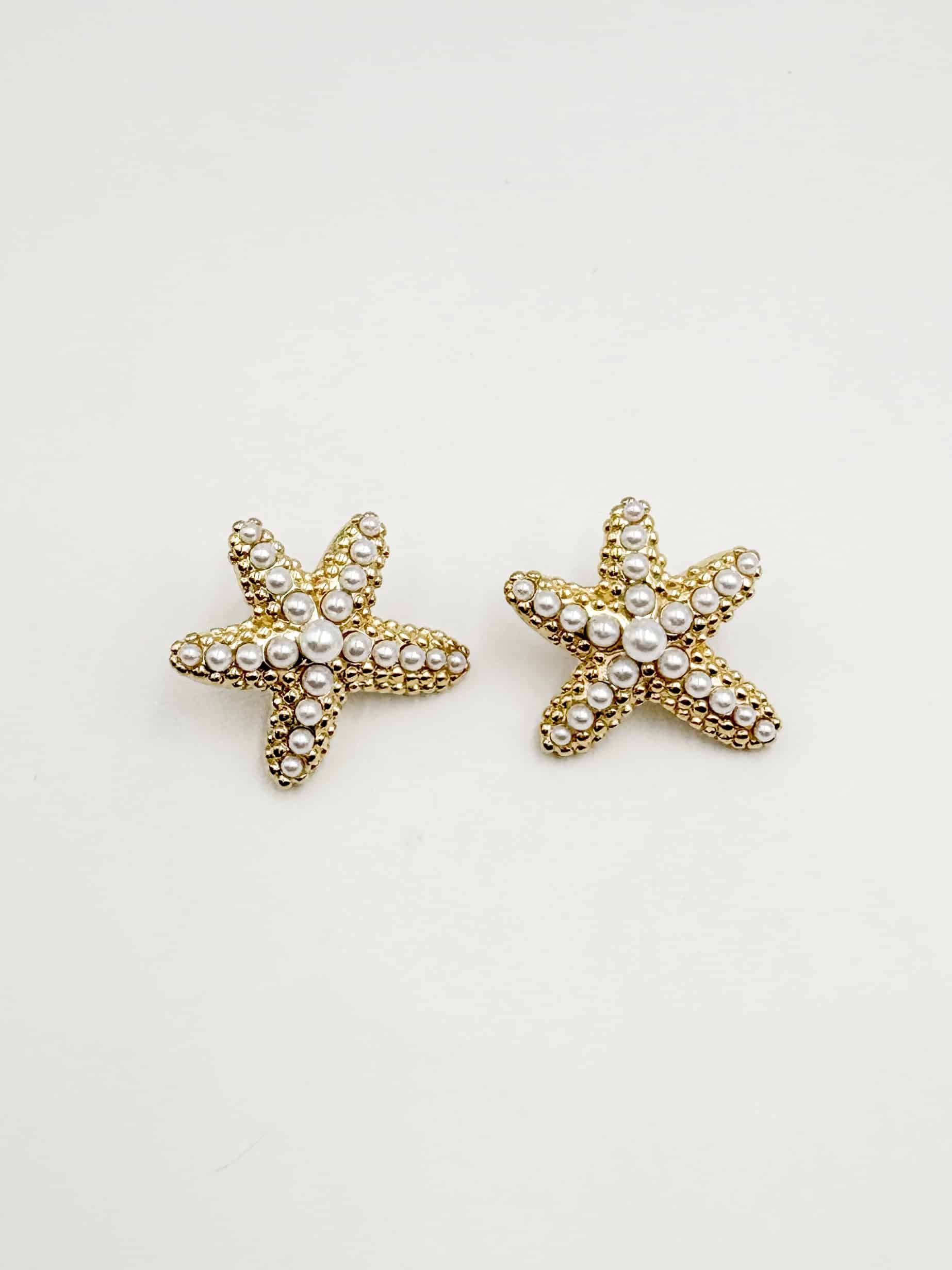 Boucles d’oreilles en acier inoxydable de couleur or, composées de deux puces d’oreilles travaillées, à la fois chic et vintage, en forme d’étoiles de mer serties de perles d'eau douce