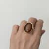 Bague large  fabriquée en acier inoxydable de couleur dorée. Vous trouverez une pierre naturelle de nacre marron en son centre.