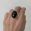 Bague LAUREEN – Bague large avec pierre naturelle d'onyx – Bijou doré en acier inoxydable Bague large  fabriquée en acier inoxydable de couleur dorée. Vous trouverez une pierre naturelle d'onyx en son centre, de couleur noire
