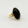 Bague LAUREEN – Bague large avec pierre naturelle d'onyx – Bijou doré en acier inoxydable Bague large  fabriquée en acier inoxydable de couleur dorée. Vous trouverez une pierre naturelle d'onyx en son centre, de couleur noire
