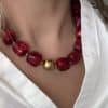 Bijou tendance composé d’une multitude de perles d’acétate marbrées de différentes couleurs framboise