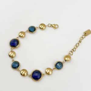 Bracelet assez large en acier inoxydable doré composé d’une ribambelle de strass dans les tons de bleu et de breloques en acier inoxydable doré– Bijou en acier inoxydable Joli bracelet assez large en acier inoxydable doré composé d’une ribambelle de strass dans les tons bleus beige et de breloques en acier inoxydable doré