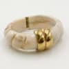 Bracelet torsadé de type jonc, manchette, en acier inoxydable et acétate de couleur beige. 