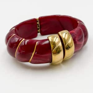 Bracelet torsadé de type jonc, manchette, en acier inoxydable et acétate de couleur framboise.