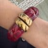 Bracelet torsadé de type jonc, manchette, en acier inoxydable et acétate de couleur framboise.