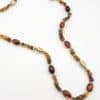 Collier sautoir composé de perles d'acétate de couleur ambre ainsi que de perles d'acier inoxydable