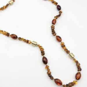 Collier sautoir composé de perles d'acétate de couleur ambre ainsi que de perles d'acier inoxydable
