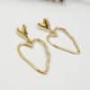 Boucles d'oreilles pendantes en acier inoxydable de couleur dorée Composées d'une puce d'oreille en forme de coeur lisse ainsi que d'un pendentif en forme de coeur martelé