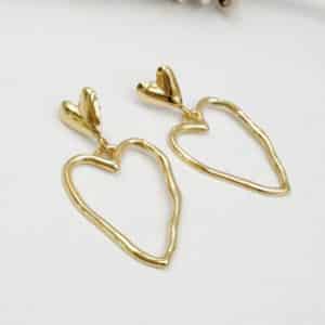 Boucles d'oreilles pendantes en acier inoxydable de couleur dorée Composées d'une puce d'oreille en forme de coeur lisse ainsi que d'un pendentif en forme de coeur martelé