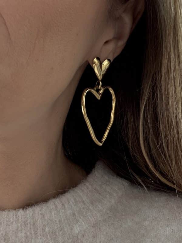 Boucles d'oreilles pendantes en acier inoxydable de couleur dorée Composées d'une puce d'oreille en forme de coeur lisse ainsi que d'un pendentif en forme de coeur martelé