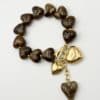 Bracelet composé d'une succession de coeurs en résine marron avec pampilles en forme de coeurs