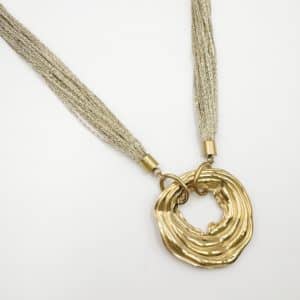 Collier composé d'une multitude de fins cordons dorés aisni que d'un large pendentif de forme ronde