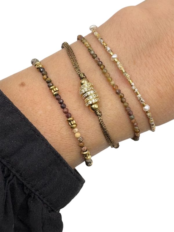 Joli bracelet fait main, ce bijou est composé de petites perles dans les tons de beige ainsi que mini perles d’eau douce véritables et finitions en acier inoxydable doré