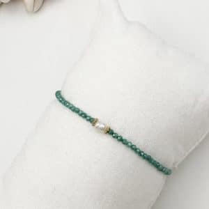 Joli bracelet fait main, ce bijou est composé de petites perles de zirconium vert émeraude ainsi que d'une fine perle d'eau douce véritable et finitions en acier inoxydable doré