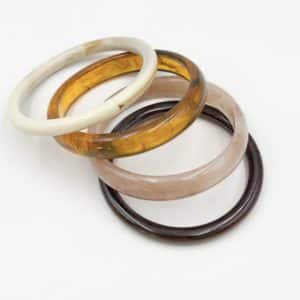 Lot de quatre bracelets à enfiler en acétate de couleur rose pâle, beige, ambre et marron
