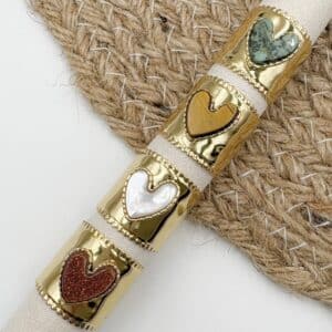 Bague large de type chevalière fabriquée en acier inoxydable de couleur dorée. Joli coeur en pierre naturelle