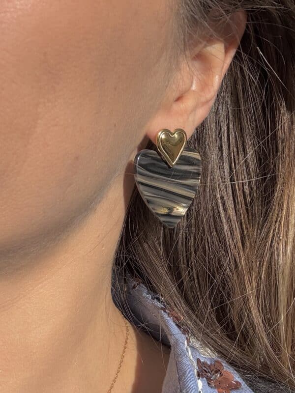 Boucles d'oreilles composées d'un coeur en acier inoxydable doré ainsi que d'un coeur en résine irisée et nacrée avec zèbrures dans les ton de beige et noir:  look rock n roll assuré, on adore