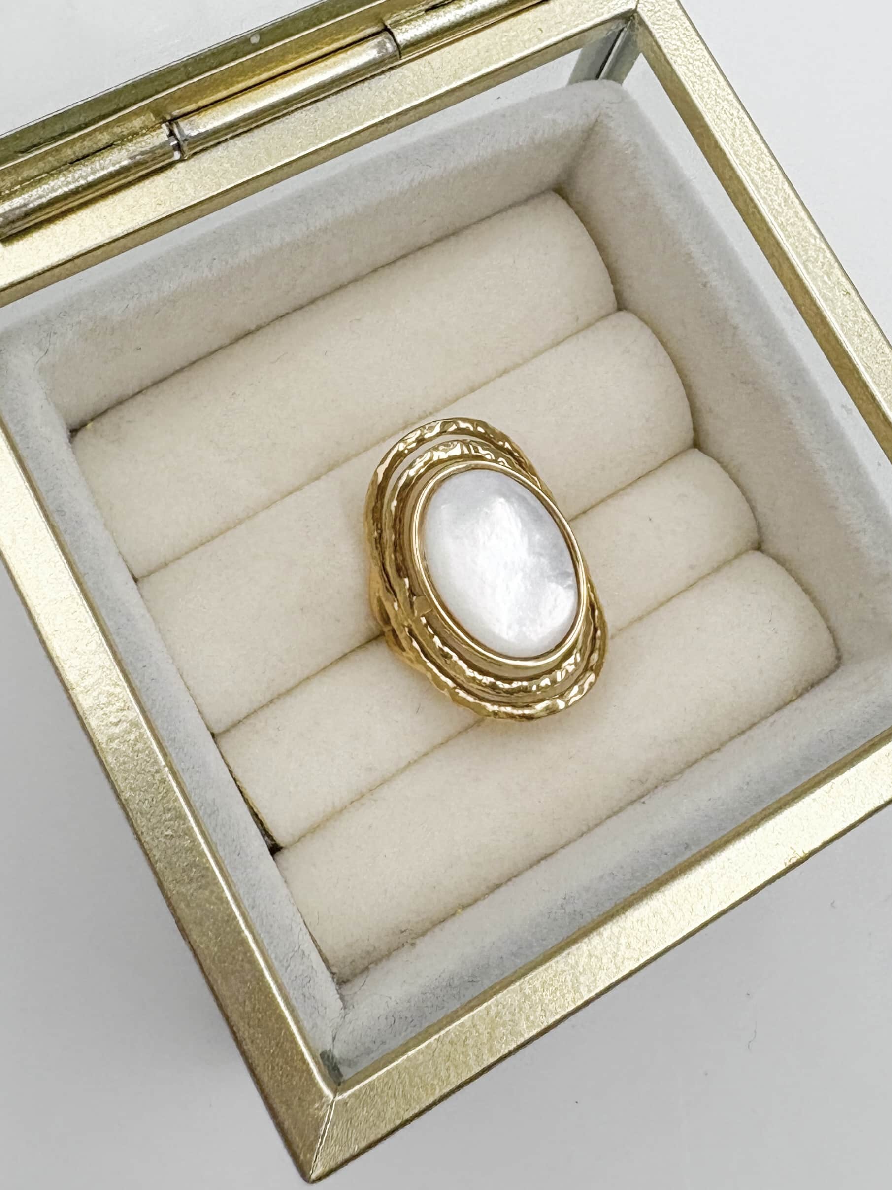 Bague large fabriquée en acier inoxydable de couleur dorée. Vous trouverez une pierre naturelle de nacre, de couleur BLANCHE
