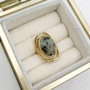 Bague large fabriquée en acier inoxydable de couleur dorée. Vous trouverez une pierre naturelle de nacre, de couleur vert de gris