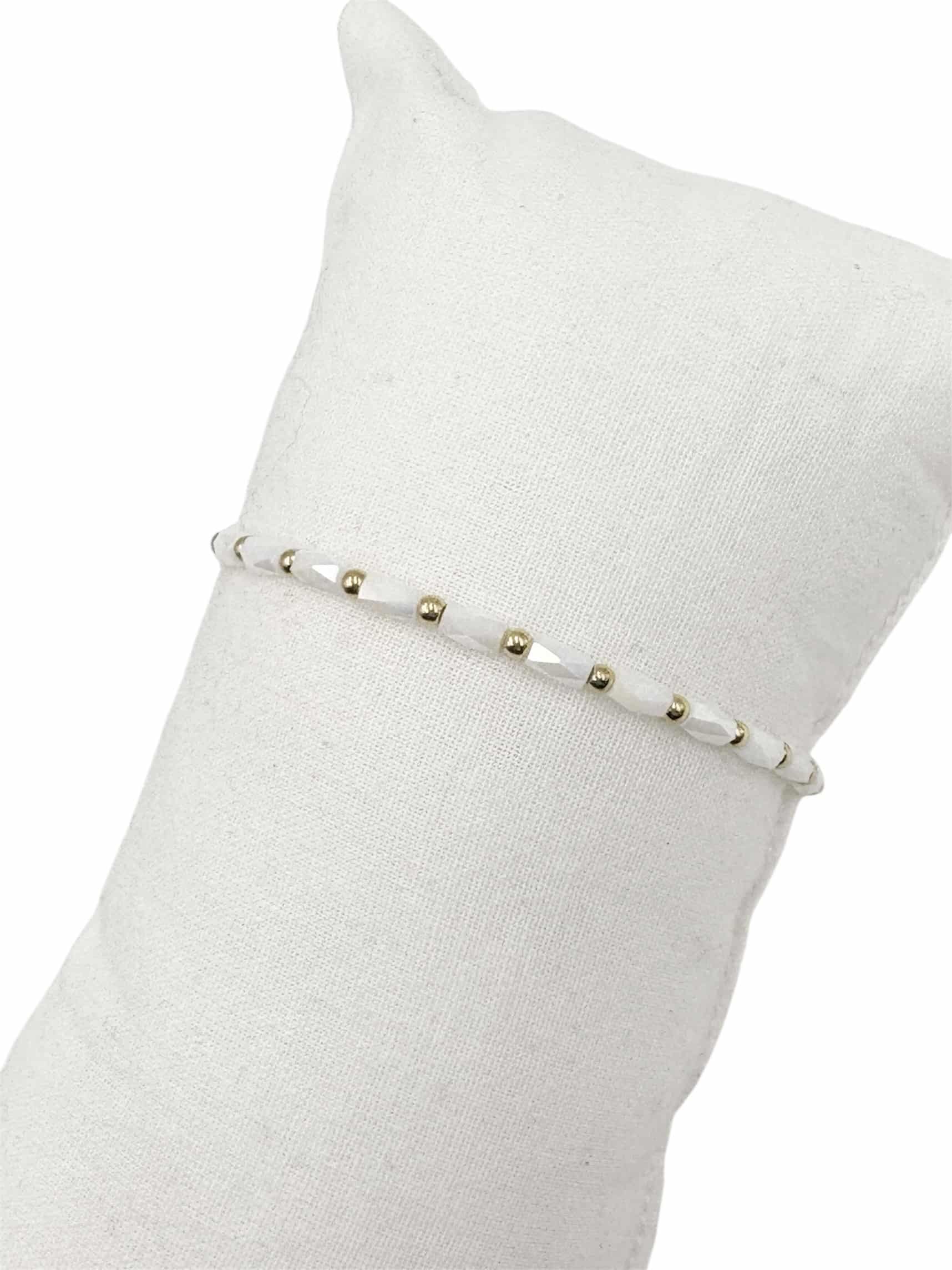 Bracelet monté sur élastique composé de perles de verre de couleur blanc et de petites billes en acier inoxydable de couleur dorée