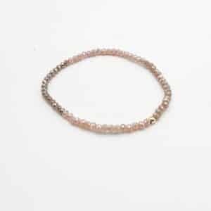 Bracelet composé de perles de verre dans un camaïeu de bleu, ainsi que d'une perle en acier inoxydable de couleur dorée