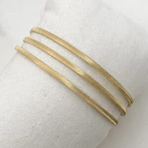 Bracelet manchette jonc en acier inoxydable doré doté de trois rangs finement ciselés