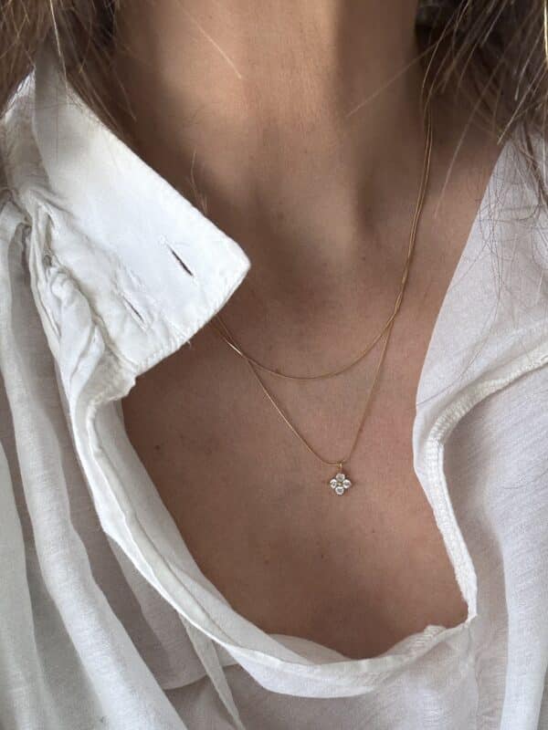 Coller double rang en acier inoxydable de couleur dorée avec petit pendentif en forme de fleur, serti de strass blancs