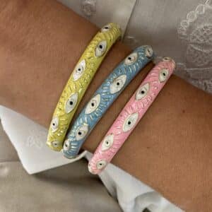Bracelet jonc de couleur dorée , émaillé de jaune, rose ou bleu et parsemé de petits yeux de protection