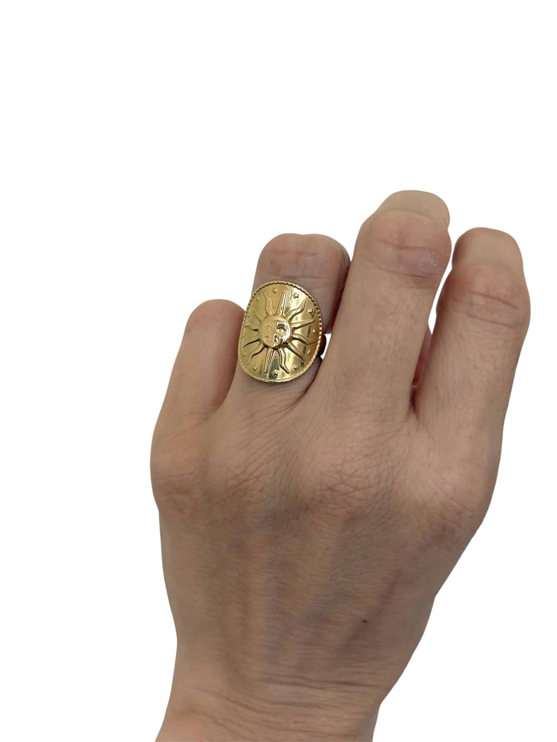 Bague assez large sur le doigt avec joli soleil au large sourire ciselé sur son dessus