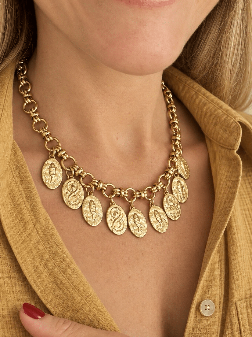 Collier en acier inoxydable doré composé d’une magnifique chaine épaisse dans un style rétro vintage ainsi que de neuf pendentifs martelés de forme ovale avec petits poissons gravés